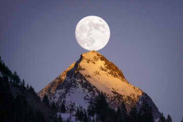 Full moon over mountain peak