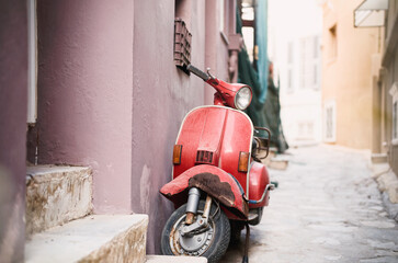 Fototapeta na wymiar Old scooter vespa model in gorgeous Ermoupolis most attractive cities in Cyclades, capital of Syros neoclassical mansions of exquisite taste and elegance, beautiful churches, and romantic alleys