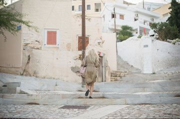 Blonde in the old Ermoupolis town of Syros. Cycladic architecture amazing panoramic views of the Aegean sea