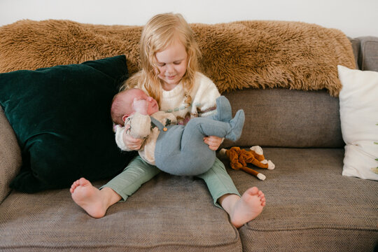 big sister holding newborn 