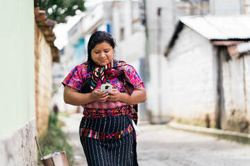 Guatemalan woman with her daughter using smartphone.