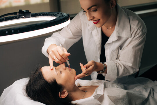 Cosmetologist doing permanent makeup procedure