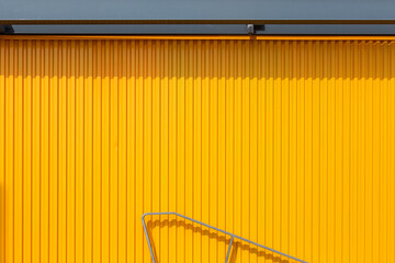 yellow wall with a piece of railing