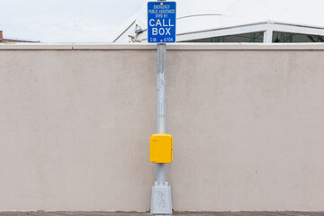 Yellow call box with a blue sign
