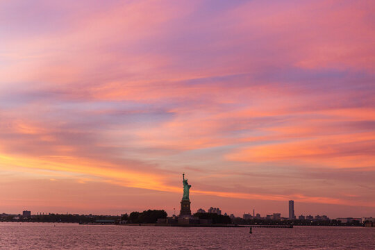 Statute of liberty in the middle of a pink sunset
