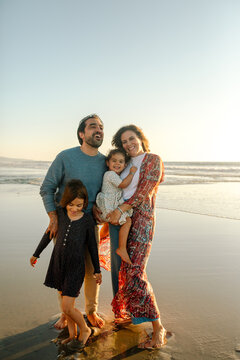 Smiling parents and two daughters at beach