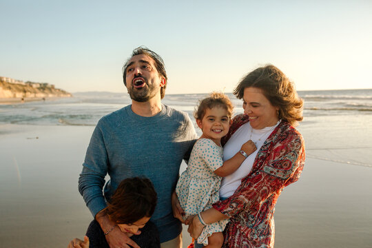Smiling parents and two daughters at beach