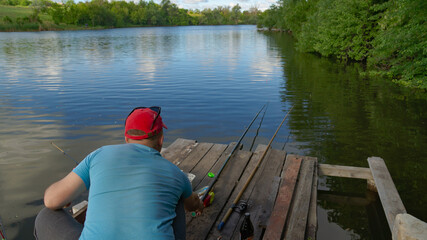Obraz premium Zheltoe village, Dnipropetrovsk region, Ukraine - May 01, 2021: Fishing with a rod on the lake. Fishing tackle.
