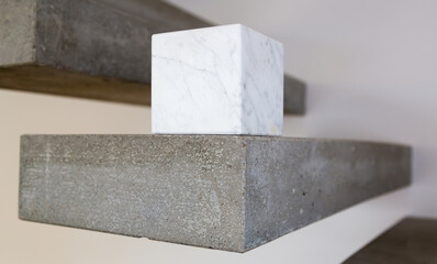 Carrara marble cube on a concrete step block; copy space composition