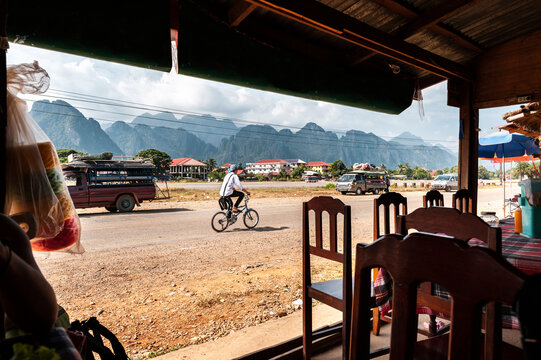 Anonimous laotian male riding bike on street