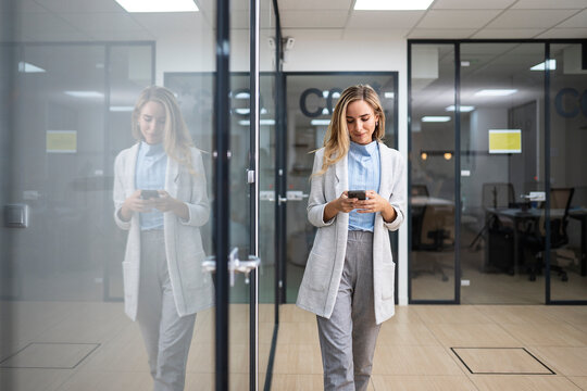 Young woman using smartphone in office.