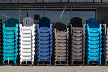 Adirondack Chairs of different colors stacked outside a retailer. Adirondack Chairs have high...