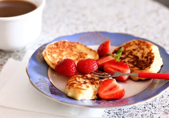 Closeup pancake with strawberries and cup of coffee milk food dessert breakfast morning beverage drink cappuccino latte caffeine plate berry plate fork nobody tasty pastry bakery