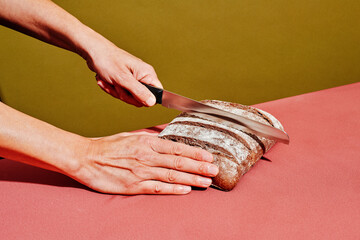 man about to cut a rye bread loaf