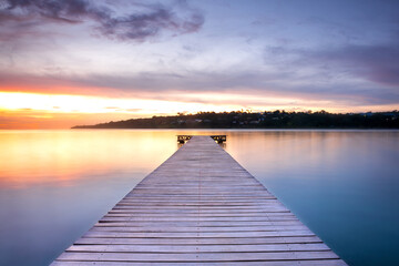 Wooden pontoon over the water sunset long exposure - obrazy, fototapety, plakaty