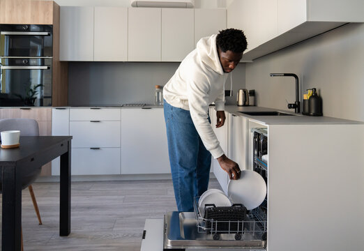 Man Putting Plates To Dishwasher