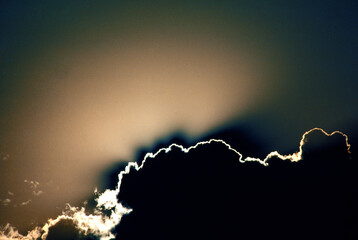 sun setting behind clouds sun rays God rays silhouetted clouds