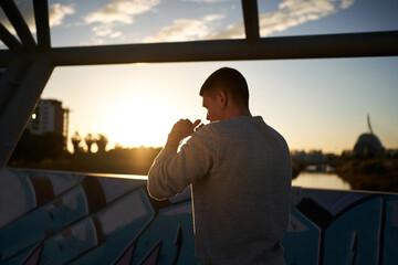 Sportsman in fighting stance on bridge in evening