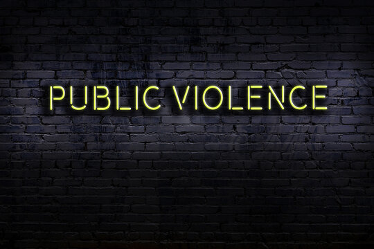 Neon Sign. Word Public Violence Against Brick Wall. Night View