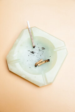 Marble ashtray full of ashes and 
old cigarettes 