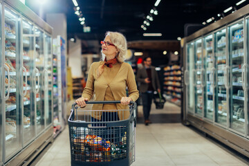 Senior woman with shopping cart in supermarket