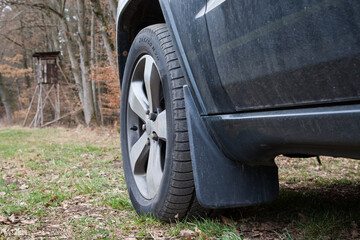 With the off-road vehicle in the hunting ground. Car tires with wheel arches on a meadow path...