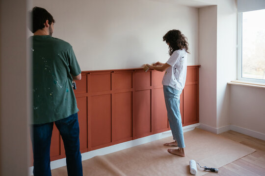 Couple repairing room together in apartment