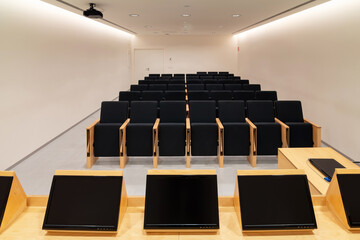 Modern displays on table in conference room with chairs