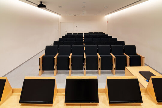Modern displays on table in conference room with chairs