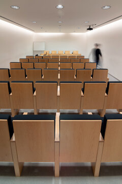 Person walking in meeting room with rows of chairs