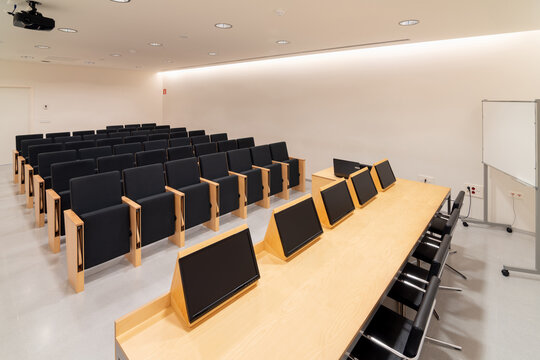 Modern displays on table in conference room with chairs