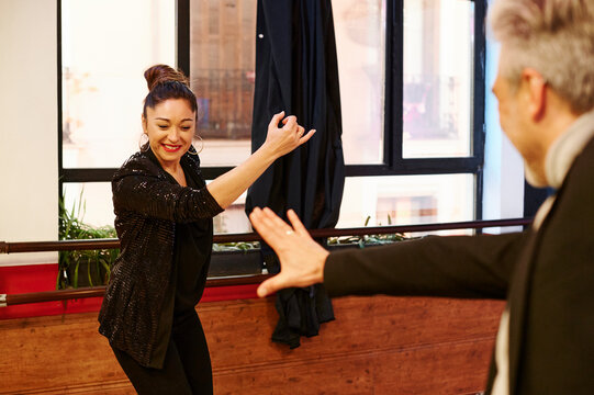 Smiling flamenco dancers rehearsing together