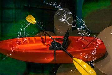 Empty red kayak, yellow paddles, water splashes, nobody, graphic background