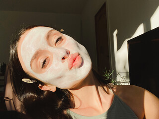 Positive woman makes a selfie with anti age mask