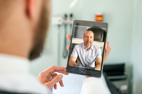 Doctor Uses Tablet For Telemedicine Session With Patient