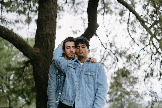 Young gay couple hugging in nature
