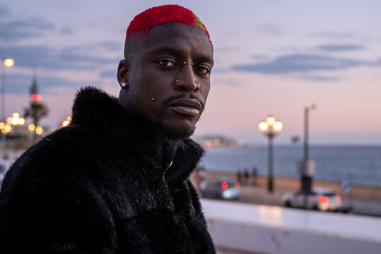Serious black man on embankment at sunset - Powered by Adobe
