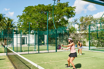 Mother and daughter playing padel outside