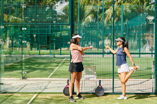 Women stretching before a padel match