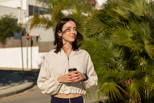 woman enjoys her take away coffee after her workout