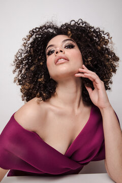 Model in maroon silk dress with glittery makeup on