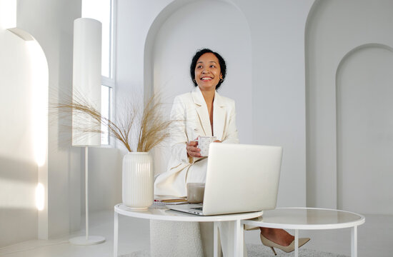 African American businesswoman drinking coffee in office