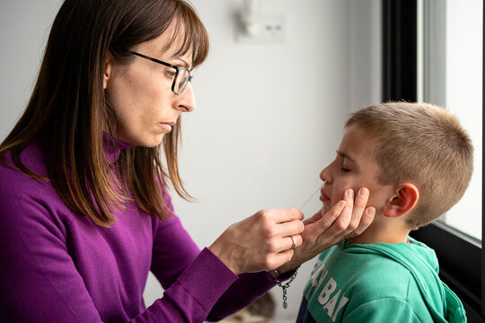 Mother testing child for coronavirus antigens