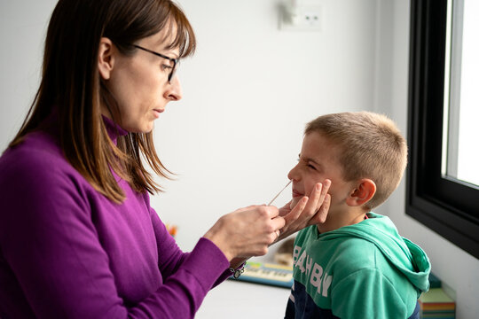 Kid wincing during COVID 19 test with mother