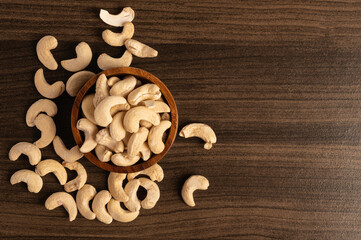 Cashew nuts in wooden bowl on table. Top view