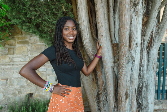 Black teen by a tree