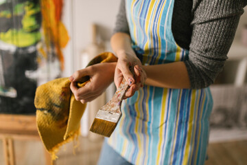 Unknown artist hands holding paint brush and cloth