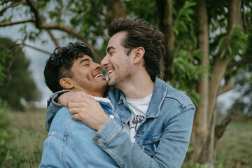 Happy Gay Couple Hugging and Smiling in Nature