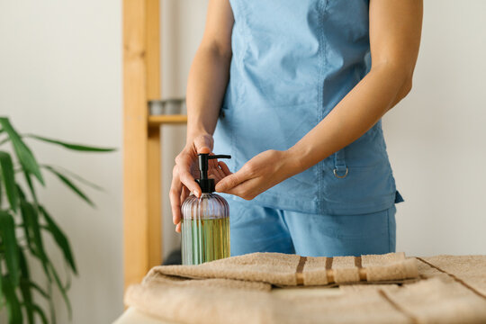 Unknown massage therapist preparing for work at spa