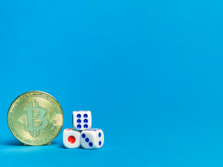 Photo of bitcoins and dices against blue background.